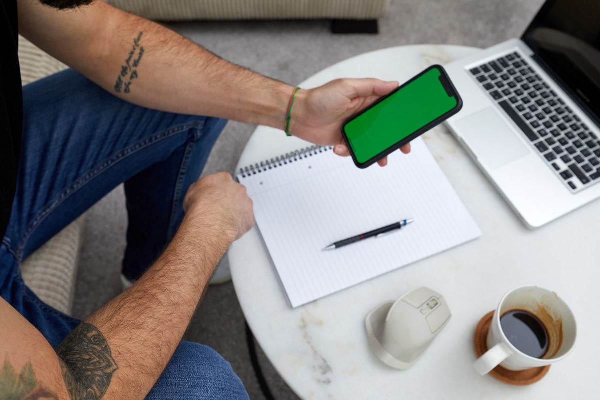 person comparing smartphones on desk uk